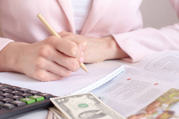istock close up of woman hands with calculator counting and taking notes to notebook 1305262586