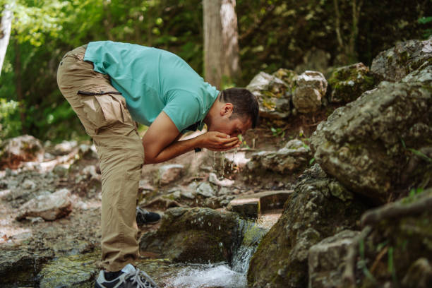 istock Man washing face in mountain river 1305263924