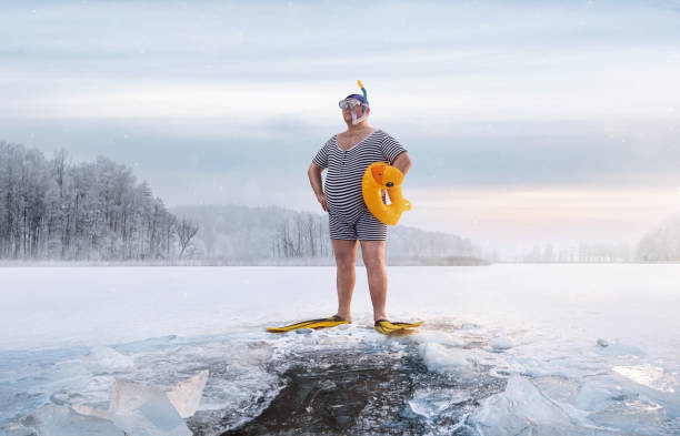 drôle de surpoids, nageur rétro restant près du trou de glace dans le lac - exercising wetsuit people expressing positivity photos et images de collection