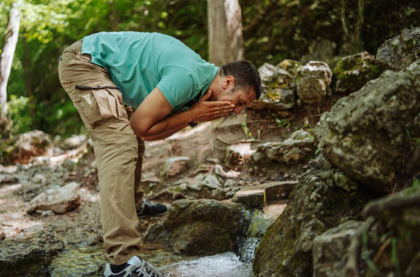 istock Man washing face in mountain river 1305264298