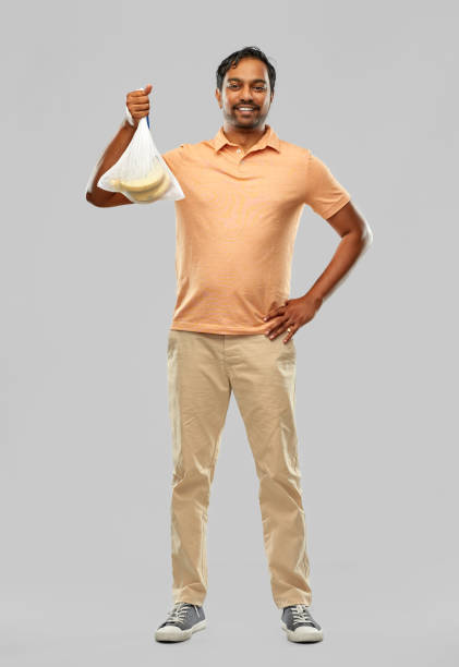 istock smiling man putting bananas into reusable net bag 1305265139