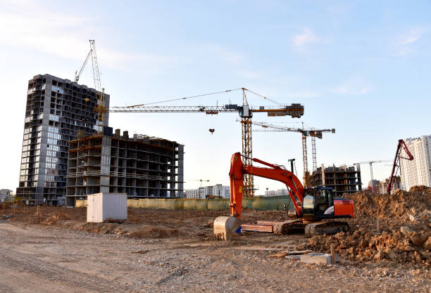istock Excavator on earthworks at construction site. Backhoe on foundation work and road construction 1305266959
