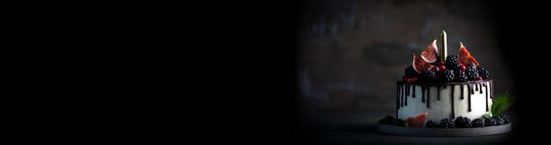 istock Cake decorated blackberries and figs with candle. Long banner 1305267012