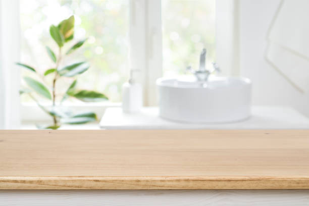 istock Bathroom sink near window with wooden table in front focus 1305269278