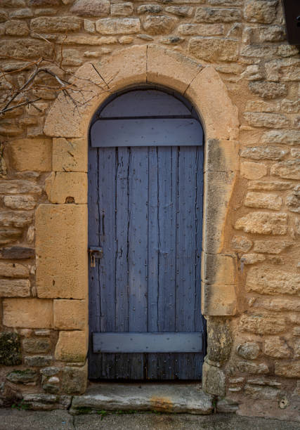 istock Old blue door in yellow stone wall with padlock. 1305269305