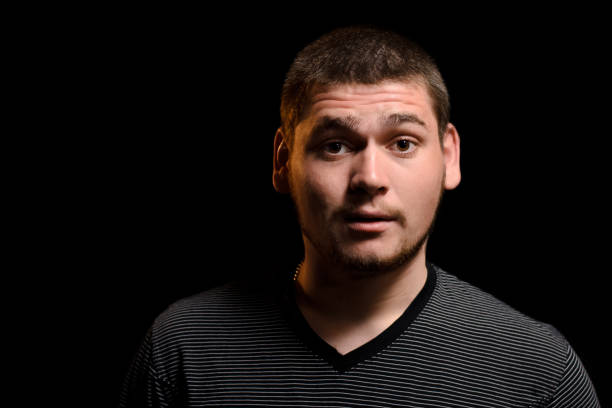 istock Surprised young man looking at camera isolated on dark background 1305269867