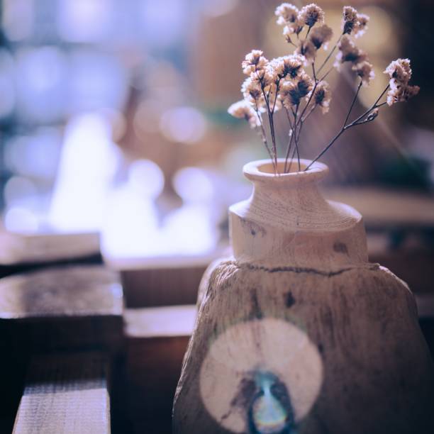 Little tree in aluminium vase on wooden table with mat , Top view photo, Concept of  clean living room