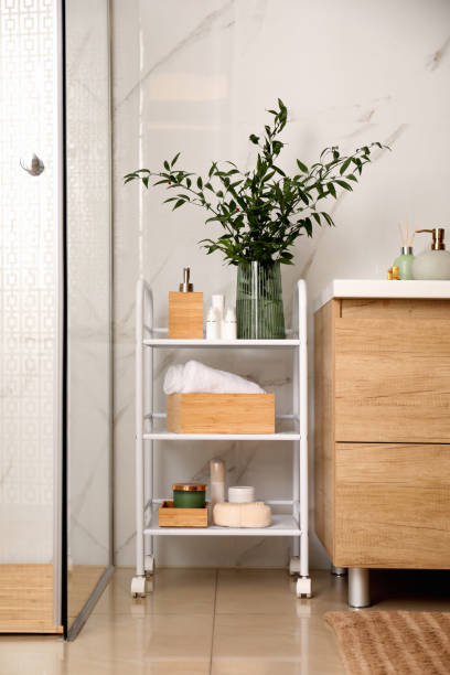 istock Vase with green branches and different toiletries on rack in bathroom 1305272096