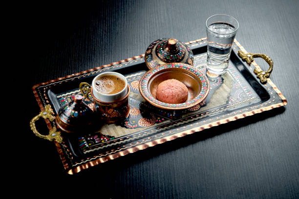 砂の中で作られた古典的なトルコのコーヒーは、装飾品、ビスケット、水と一緒に国のトレイで提供しています。暗い背景 - cup coffee pot coffee coffee cup ストックフォトと画像