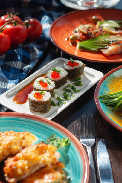 istock Appetizing homemade sushi rolls on the table in a beautiful setting, sunny lighting 1305272264