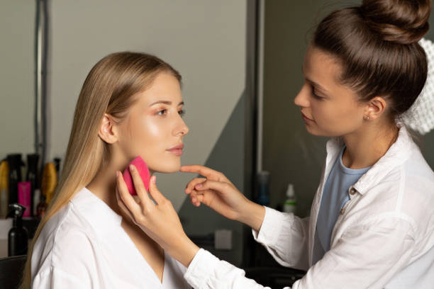 istock Professional makeup artist applying liquid foundation 1305272679