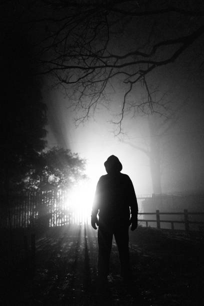 istock Sinister silhouette man lurking in forest at night 1305273719