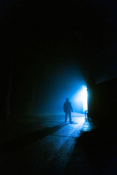 istock Sinister silhouette man lurking in forest at night 1305273722