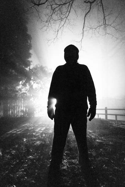 Two people walking down a dark alley in the evening fog