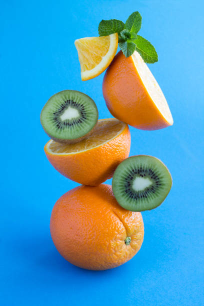 istock Oranges and kiwi stacked pyramid on the blue background 1305277126