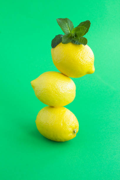 istock Lemons stacked pyramid on the green background 1305277128
