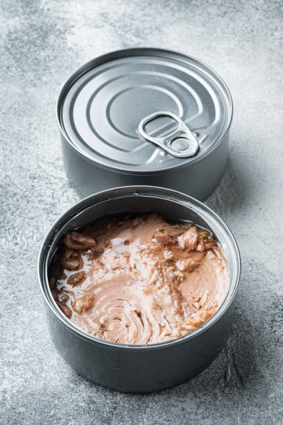 istock Tuna in a can, whole and chopped, in tin can, on gray background 1305277213