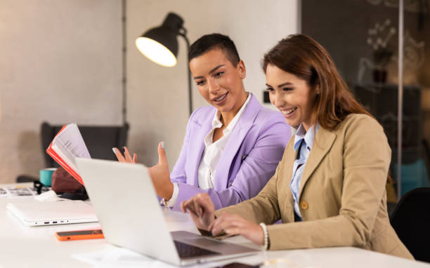 istock Female colleagues using laptop in the office 1305278253
