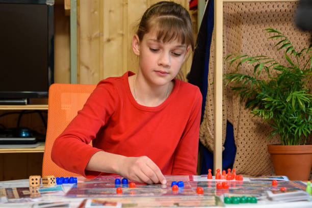 istock A girl makes another move with chips while playing a board game at the table 1305283368