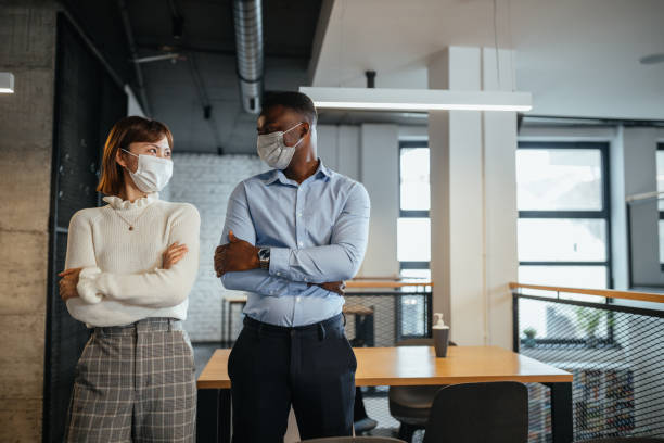 istock Mixed race colleagues at work during pandemic 1305283960