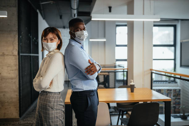 istock Mixed race colleagues at work during pandemic 1305284527