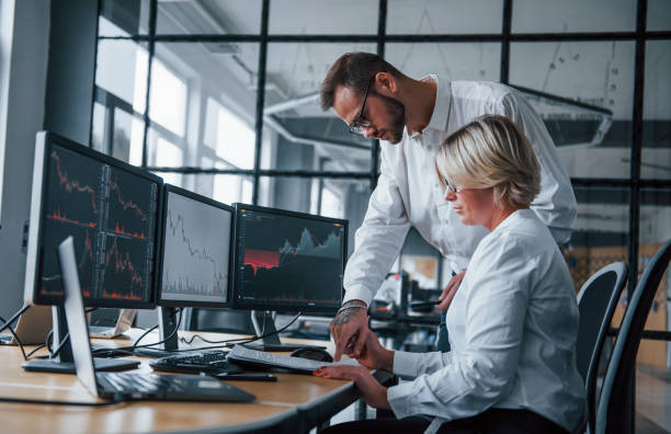 istock Analyzing information together. Two stockbrokers in formal clothes works in the office with financial market 1305286157