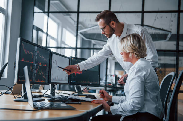istock Analyzing information together. Two stockbrokers in formal clothes works in the office with financial market 1305286220