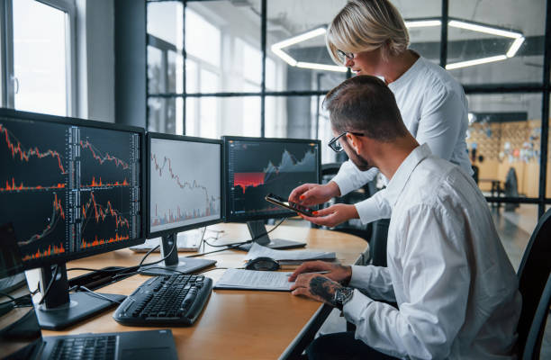 istock Analyzing information together. Two stockbrokers in formal clothes works in the office with financial market 1305286380