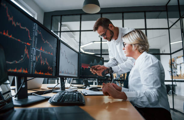 istock Analyzing information together. Two stockbrokers in formal clothes works in the office with financial market 1305286411