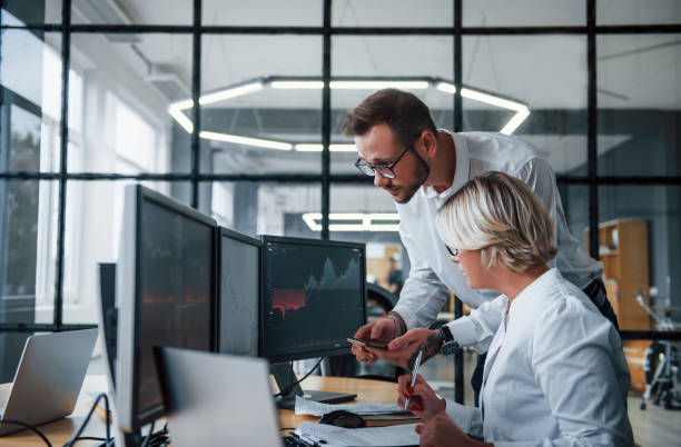 istock Analyzing information together. Two stockbrokers in formal clothes works in the office with financial market 1305286420