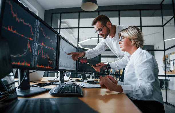 istock Analyzing information together. Two stockbrokers in formal clothes works in the office with financial market 1305286421