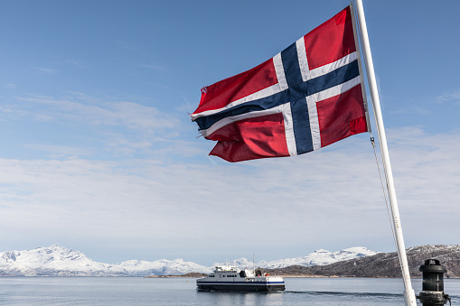 Icelandic flag on a pole floating in the wind on blue sky background, panoramic web banner web banner