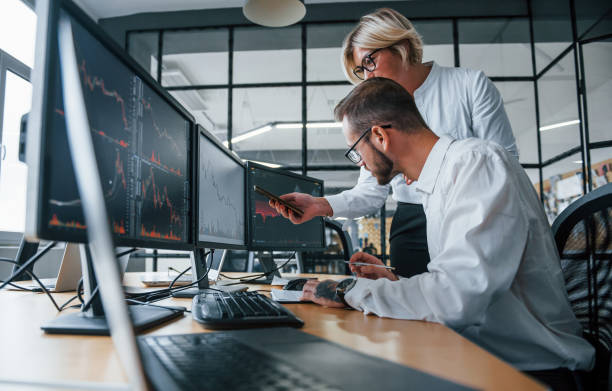 istock Analyzing information together. Two stockbrokers in formal clothes works in the office with financial market 1305286441