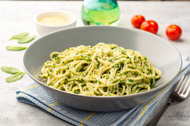 istock Spaghetti pasta with spinach sauce and parmesan cheese on concrete background 1305287853