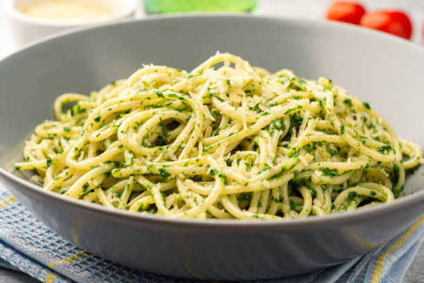 istock Spaghetti pasta with spinach sauce and parmesan cheese on concrete background 1305287866