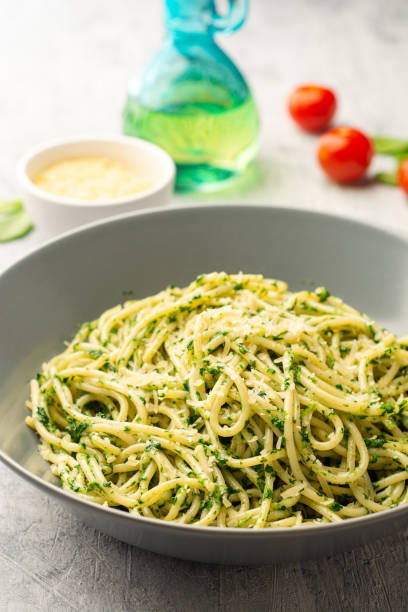 istock Spaghetti pasta with spinach sauce and parmesan cheese on concrete background 1305287868