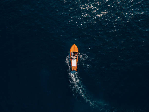 a wooden sports boat with people on board rides on the sea. luxury wooden motor boat - top view from drone. - speedboat leisure activity relaxation recreational boat imagens e fotografias de stock