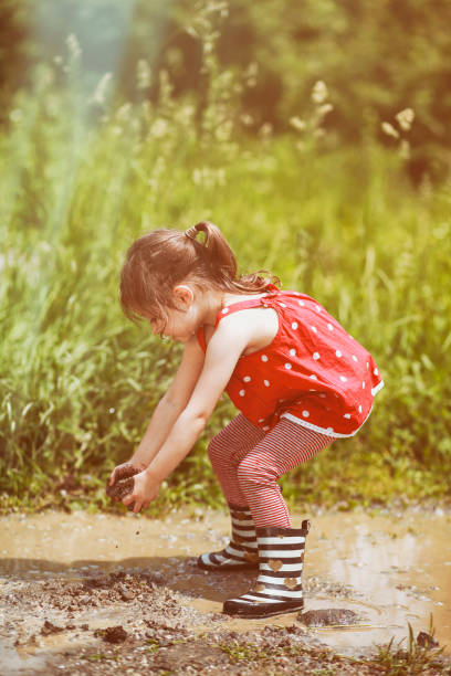 istock Littile girl having fun in mud 1305288996