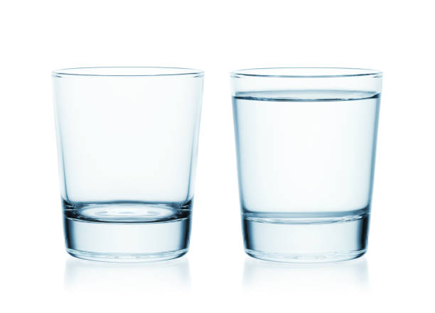 istock Full and empty glass of water isolated on white background. 1305289219