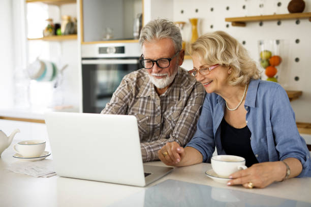 istock Senior couple checking their bills using laptop in the kitchen 1305291990
