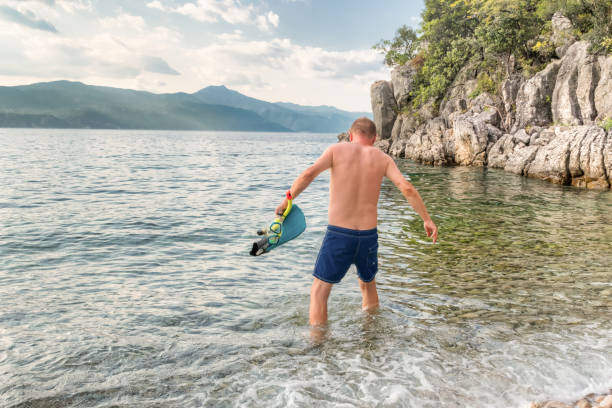 istock Man on the Beach Holiday Going Snorkeling at the Sunset 1305292138