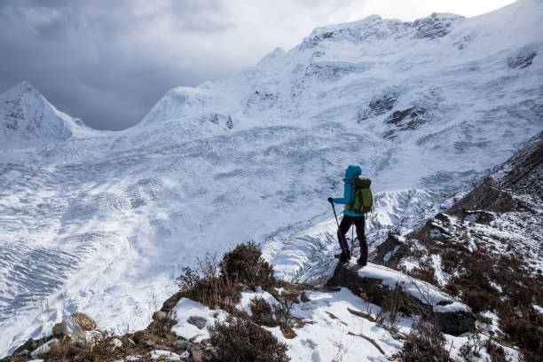 istock Successful woman backpacker hiking in winter mountains 1305293912
