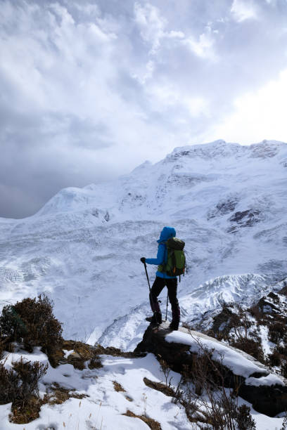 istock Successful woman backpacker hiking in winter mountains 1305293988