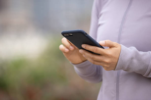 istock Asian woman using smartphone outdoors 1305295407