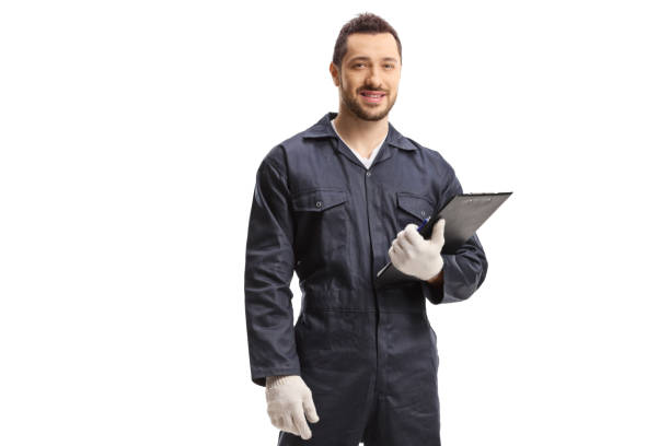 istock Worker in a jumpsuit standing and holding a clipboard 1305295583
