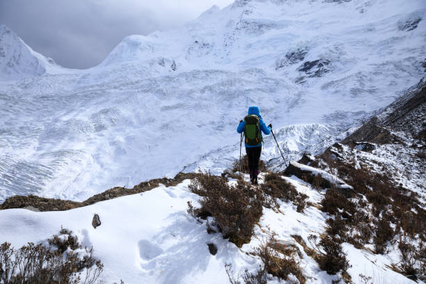 istock Successful woman backpacker hiking in winter mountains 1305295586