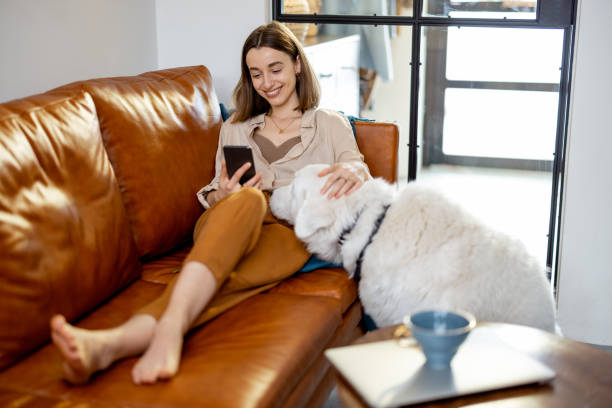istock Woman sitting on the sofa at home with a dog. 1305296038