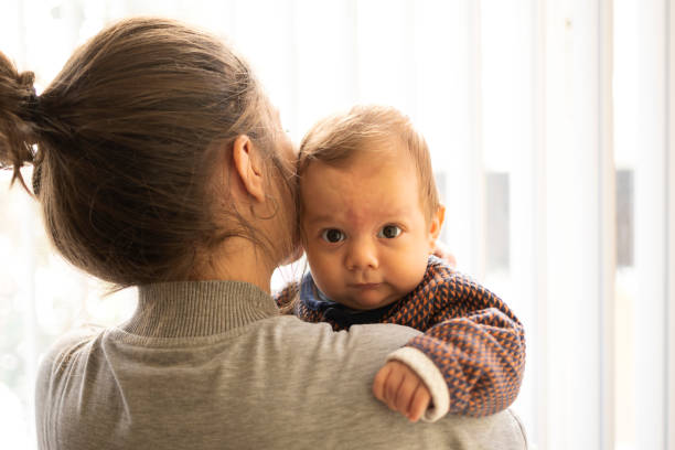 Mother holding her newborn baby boy stock photo