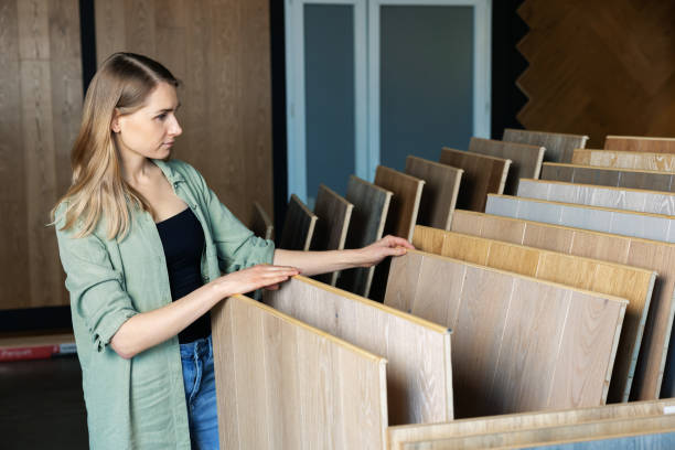 istock woman choosing laminate floor design from samples in flooring store 1305296320