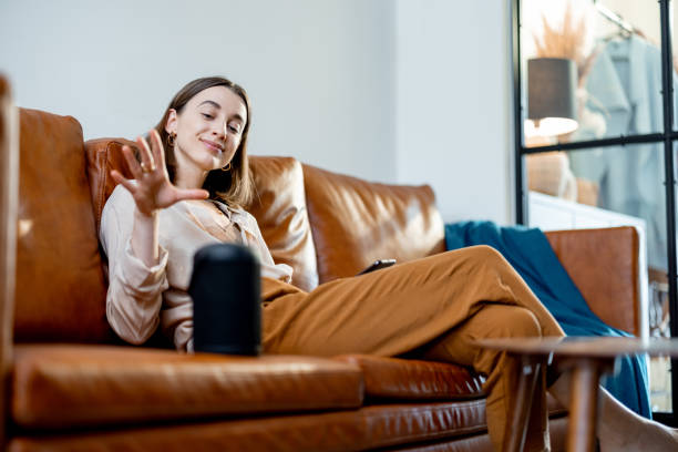 istock Woman speaking with audio assistant column on sofa 1305297047
